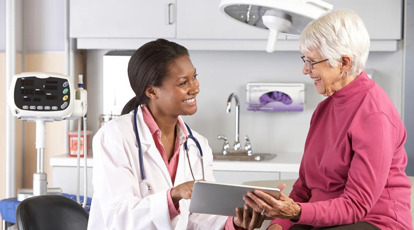 A female physician talking to an elderly female patient