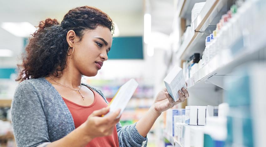 Shot of a young woman browsing the shelves of a pharmacy